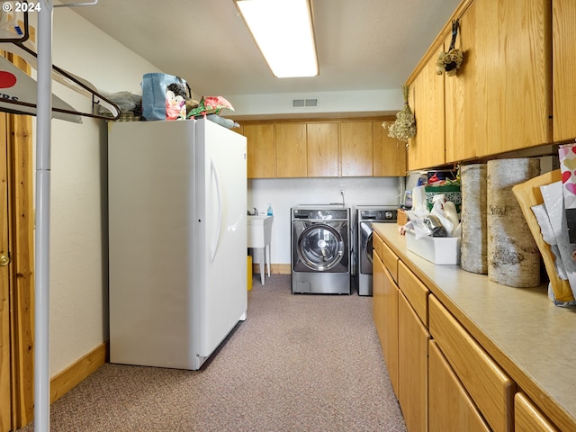 washroom featuring light colored carpet, cabinets, and washer and clothes dryer