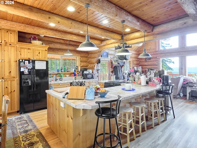 kitchen with a kitchen island, light hardwood / wood-style floors, wood ceiling, black fridge with ice dispenser, and rustic walls