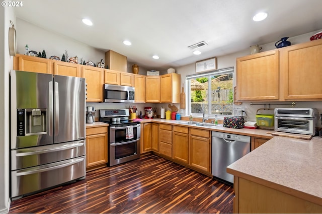 kitchen featuring appliances with stainless steel finishes, sink, dark hardwood / wood-style floors, and light brown cabinets