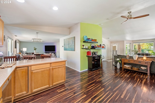 kitchen featuring light brown cabinetry, ceiling fan with notable chandelier, dark wood-type flooring, lofted ceiling, and hanging light fixtures