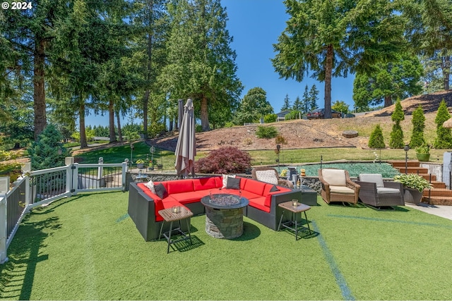 view of yard with an outdoor living space with a fire pit