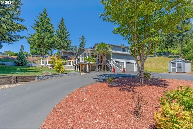 view of front of home with a garage, a storage shed, and a front lawn