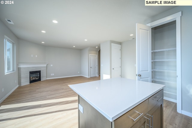 kitchen featuring a kitchen island, visible vents, light countertops, and open floor plan