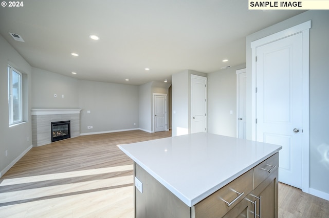 kitchen featuring visible vents, open floor plan, light countertops, and a center island