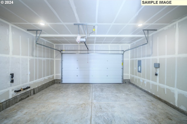 garage with a garage door opener and electric panel