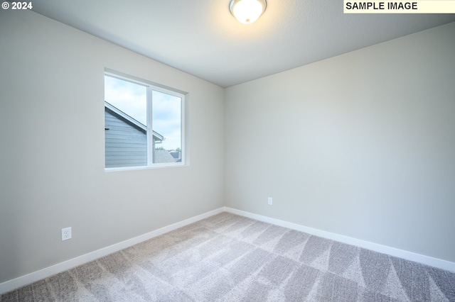 empty room featuring carpet flooring and baseboards