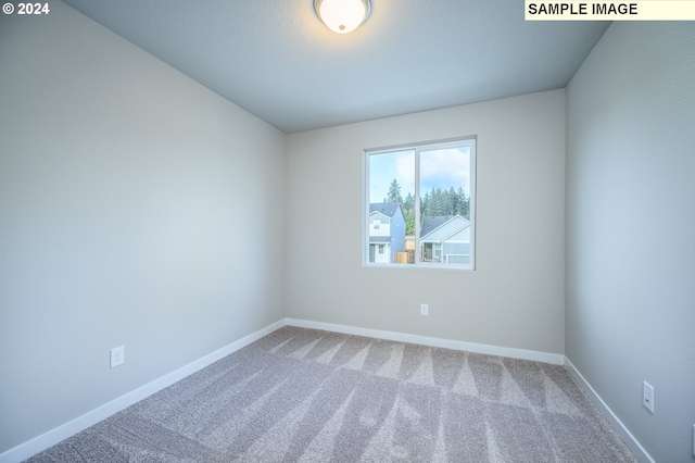 carpeted spare room with baseboards