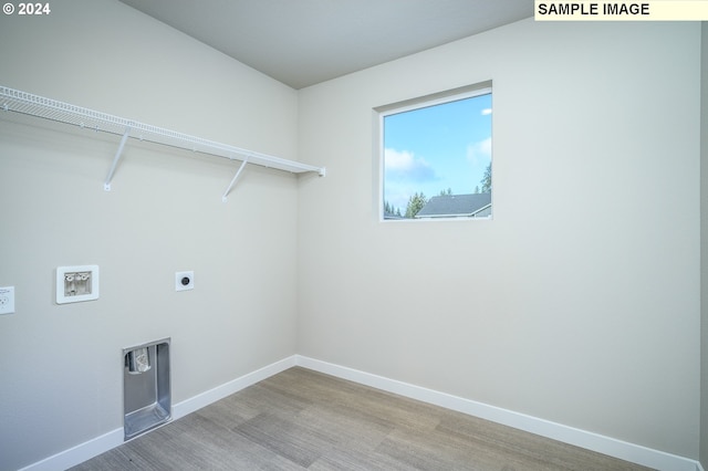 clothes washing area featuring washer hookup, light wood-style flooring, electric dryer hookup, laundry area, and baseboards