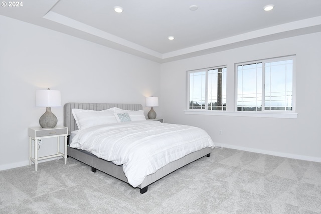 carpeted bedroom featuring a tray ceiling