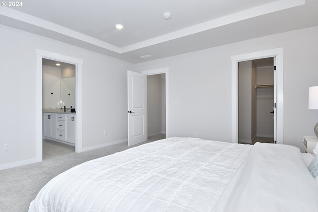 carpeted bedroom with a spacious closet, a closet, and connected bathroom