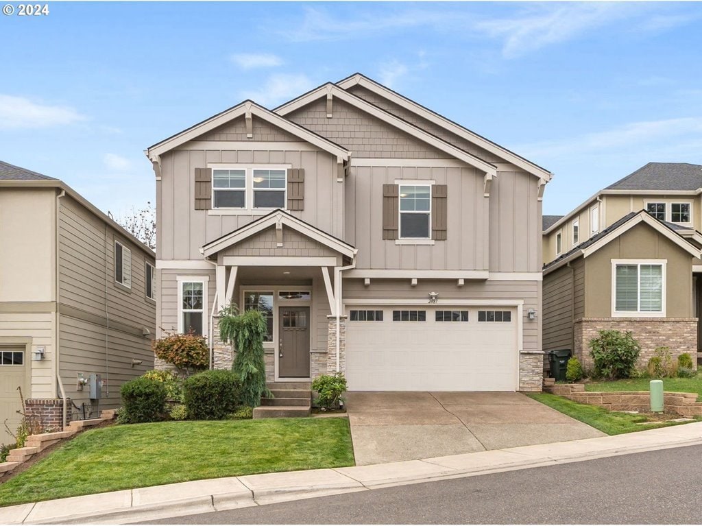 craftsman-style house featuring a front lawn and a garage