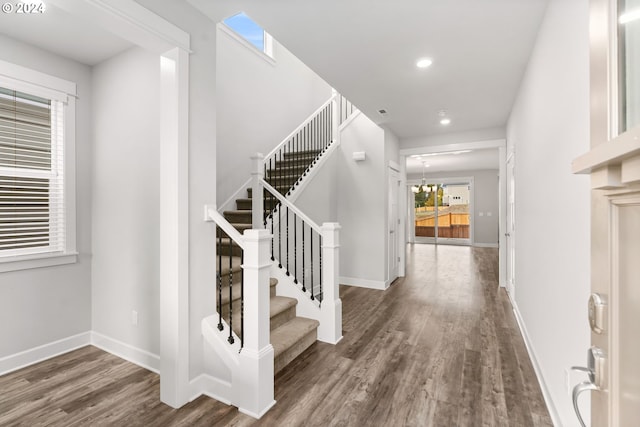 entrance foyer with an inviting chandelier and dark hardwood / wood-style floors