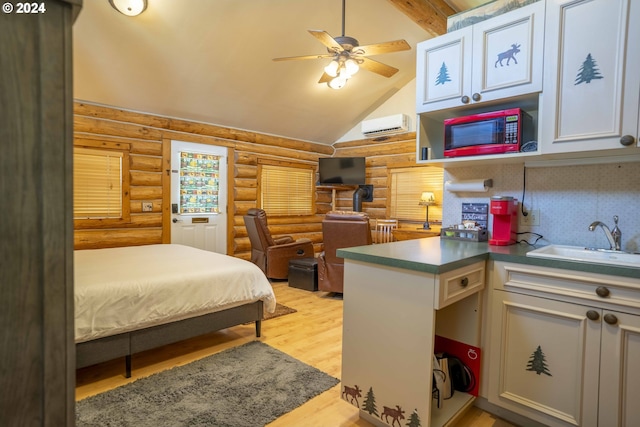 bedroom with sink, ceiling fan, beam ceiling, log walls, and light hardwood / wood-style floors