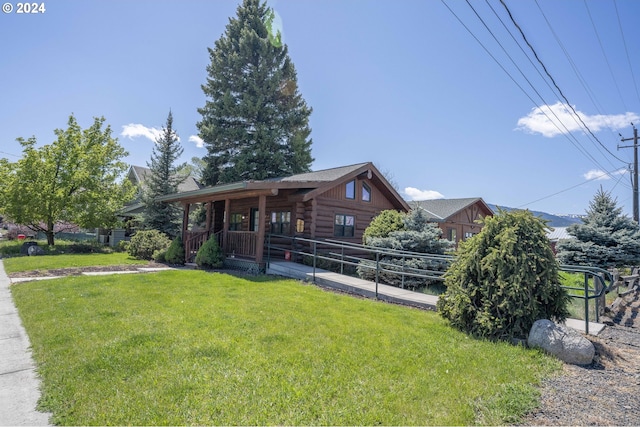 cabin with covered porch and a front yard