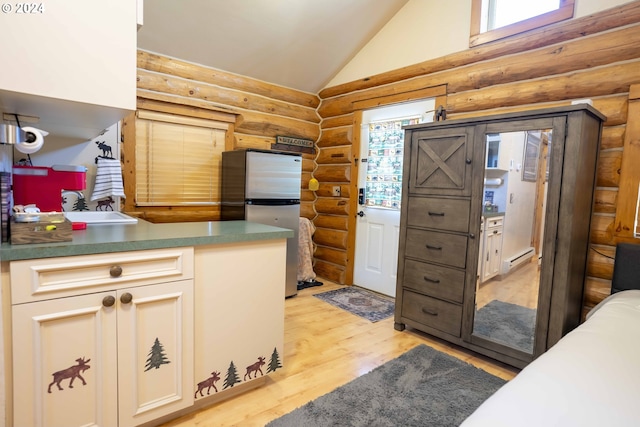 kitchen with lofted ceiling, a baseboard heating unit, light hardwood / wood-style flooring, stainless steel fridge, and rustic walls