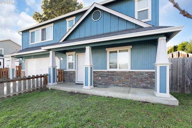 craftsman house with a garage, a front yard, and a porch