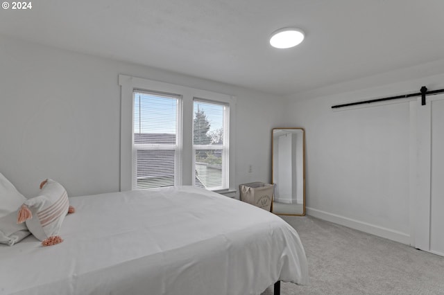 carpeted bedroom featuring a barn door