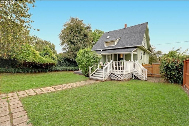 back of property featuring a lawn and covered porch