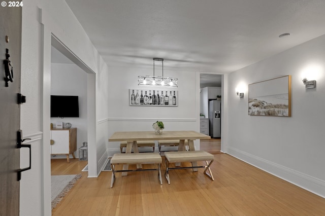 dining area with a chandelier and light hardwood / wood-style floors