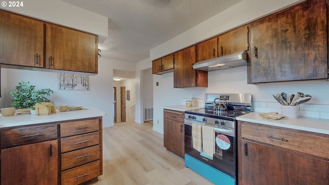 kitchen featuring a textured ceiling, stainless steel range with electric cooktop, and light wood-type flooring