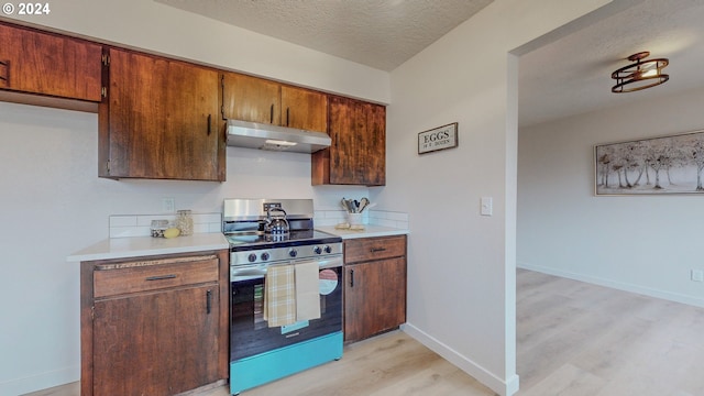 kitchen with a textured ceiling, stainless steel range with electric cooktop, and light hardwood / wood-style flooring