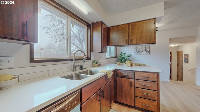 kitchen with light hardwood / wood-style floors, sink, and a textured ceiling