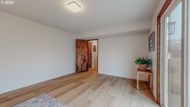 empty room featuring light wood-type flooring and a textured ceiling