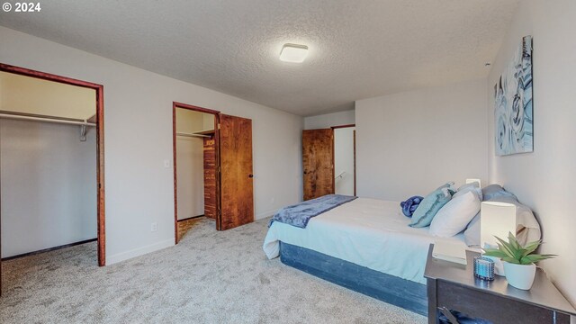 bedroom featuring a textured ceiling and light colored carpet