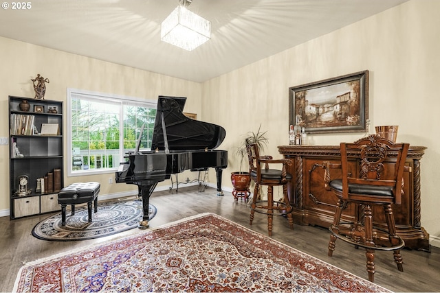 living area with indoor bar, dark hardwood / wood-style flooring, and an inviting chandelier