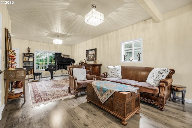 living room with a chandelier, hardwood / wood-style flooring, and beam ceiling