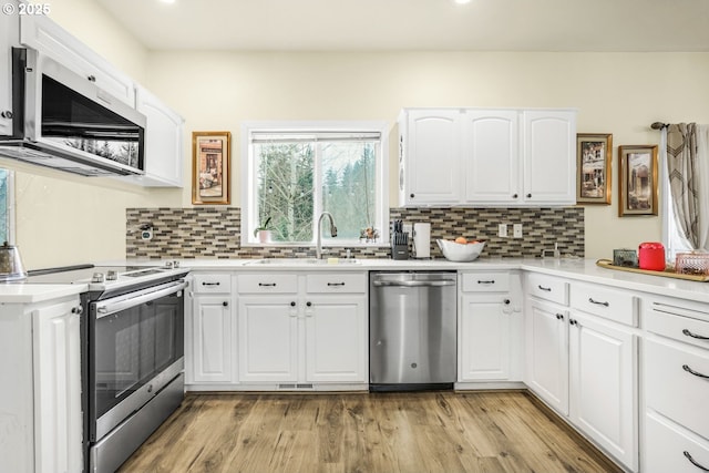 kitchen featuring sink, white cabinets, tasteful backsplash, and appliances with stainless steel finishes