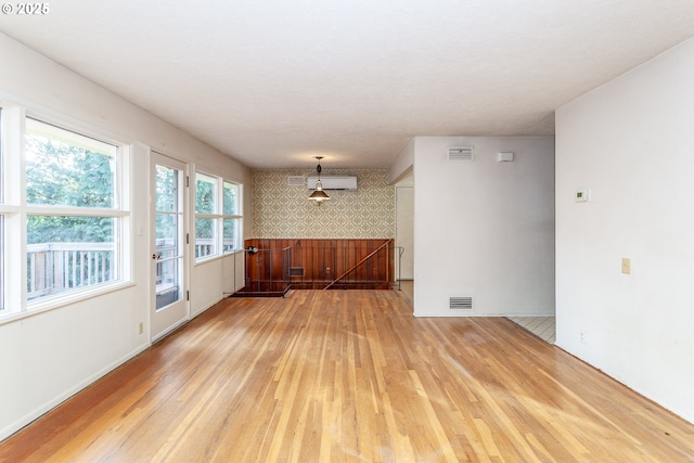 unfurnished room featuring light hardwood / wood-style floors and an AC wall unit