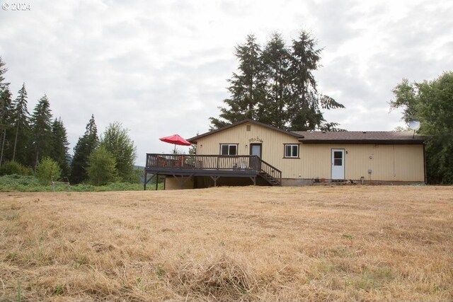 back of house featuring crawl space, a lawn, and a wooden deck