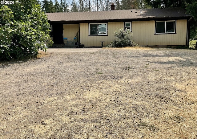 view of front of property featuring gravel driveway and a chimney