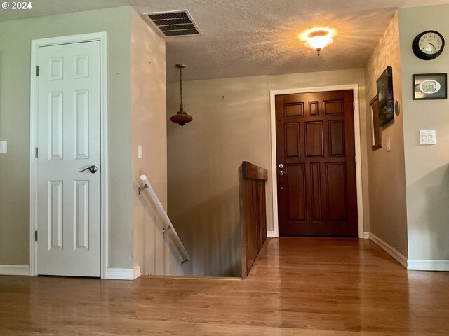 foyer featuring a textured ceiling and hardwood / wood-style flooring