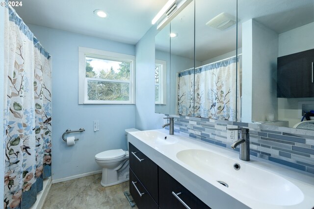 bathroom featuring vanity, curtained shower, toilet, and backsplash