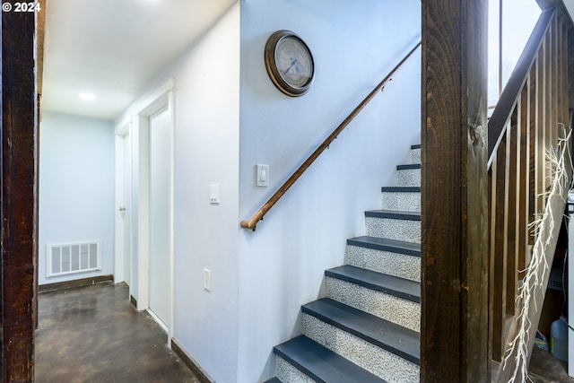 staircase featuring concrete flooring