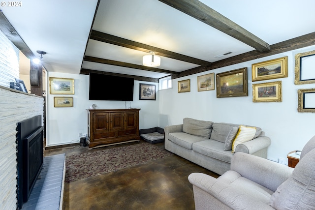 living room featuring beam ceiling and a stone fireplace