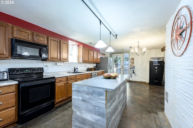 kitchen featuring pendant lighting, black appliances, sink, a kitchen island, and a chandelier