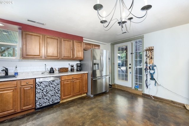 kitchen with appliances with stainless steel finishes, a wealth of natural light, pendant lighting, and a notable chandelier