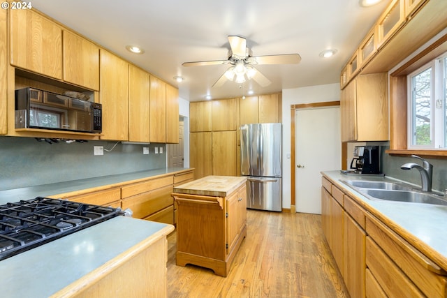 kitchen with stainless steel refrigerator, sink, tasteful backsplash, a kitchen island, and light wood-type flooring