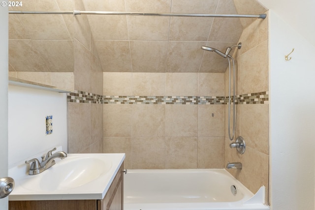 bathroom featuring tiled shower / bath combo and vanity