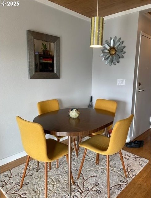 dining room with wood ceiling, baseboards, and wood finished floors