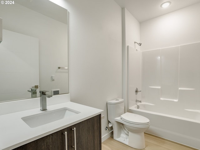 full bathroom featuring shower / washtub combination, hardwood / wood-style floors, vanity, and toilet