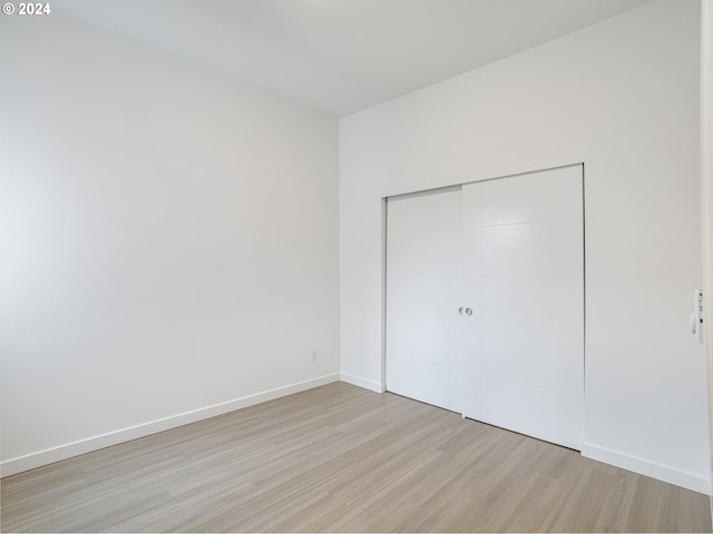 unfurnished bedroom with light hardwood / wood-style floors and a closet