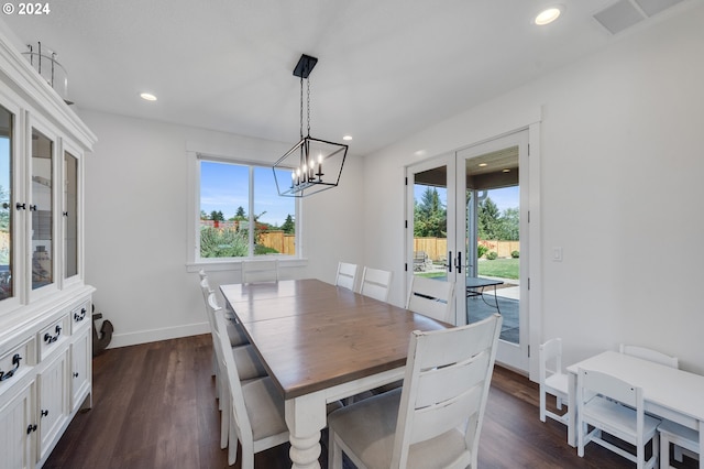 dining area with dark hardwood / wood-style floors, a chandelier, and french doors