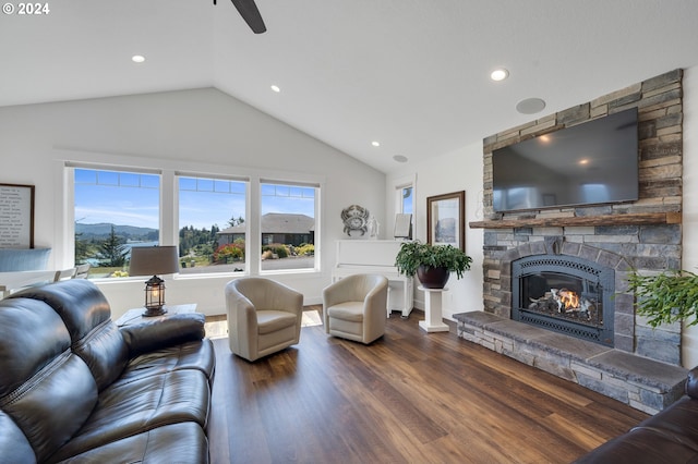 living room with lofted ceiling, a stone fireplace, hardwood / wood-style floors, and a wealth of natural light