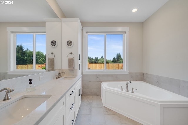 bathroom with a bathtub, tile walls, vanity, and tile patterned floors