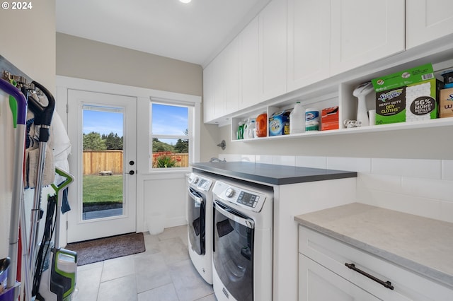 washroom featuring cabinets, light tile patterned flooring, and washing machine and dryer