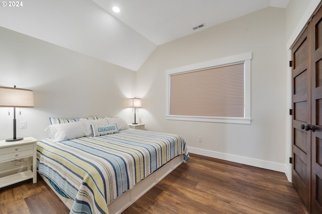 bedroom with lofted ceiling and dark hardwood / wood-style flooring